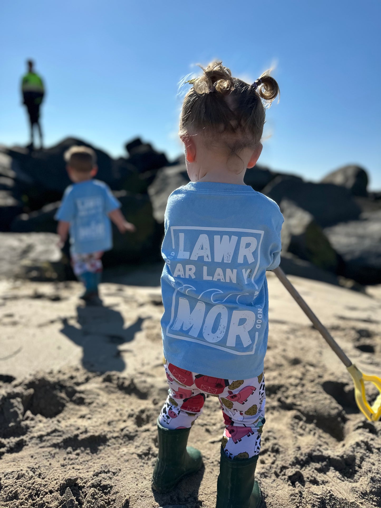 Crys T Lawr ar lan y môr Tee
